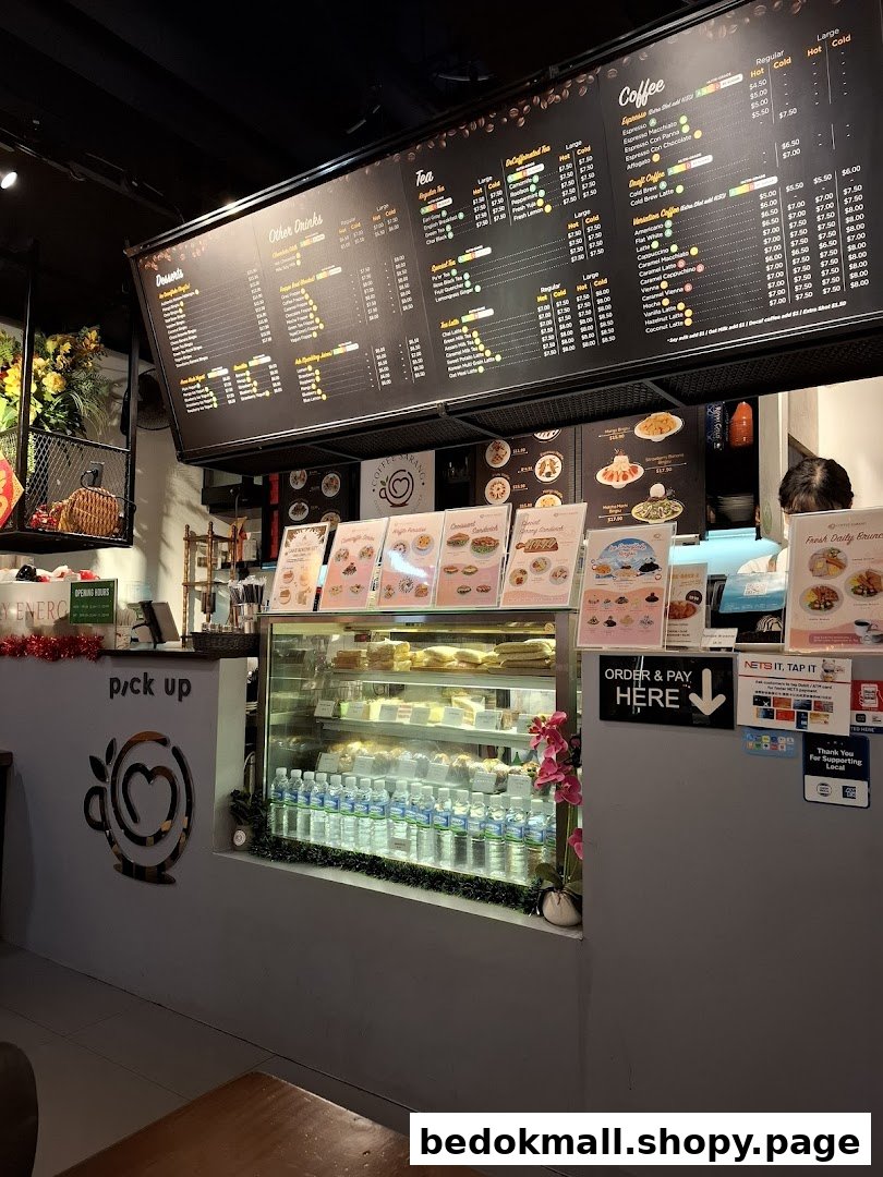 Interior view of a coffee shop counter with a large menu board and display case.