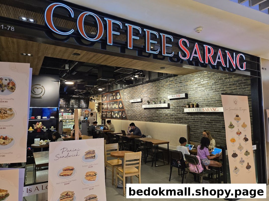 Coffee shop entrance with prominent signage and customers inside.