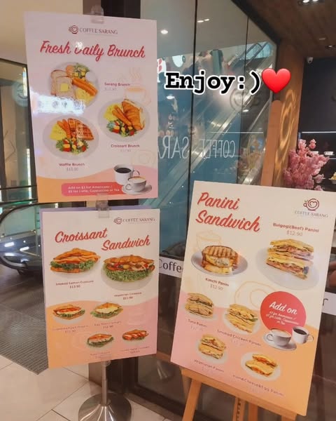 Three display boards show various food menus and prices for Coffee Sarang.