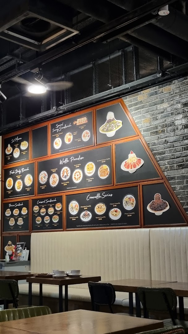 Cafe interior with a large wall-mounted menu displaying food items.