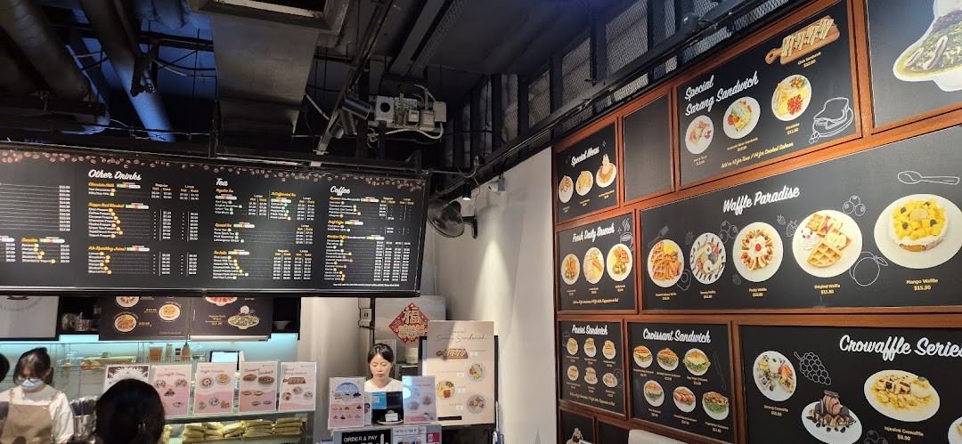 Interior of a coffee shop with large menu boards displaying food and drinks.