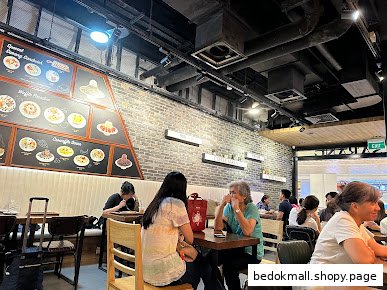Interior view of a cafe with customers seated at tables.