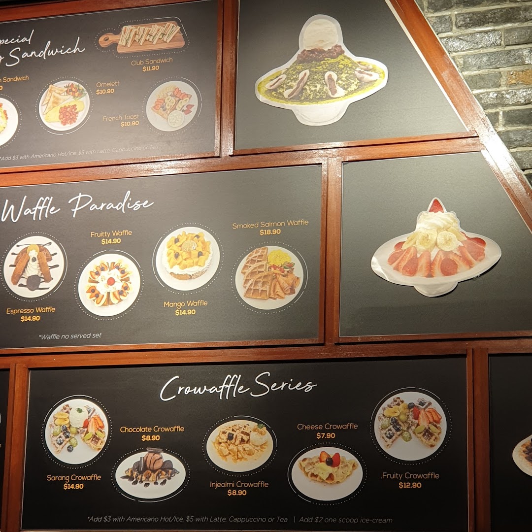 A display board showing various food items like waffles and sandwiches with prices.