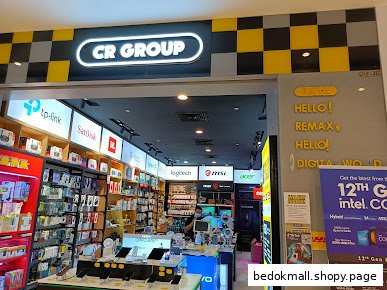 Electronics shop entrance with 'CR GROUP' sign and products visible inside.