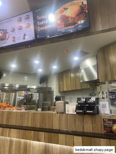 Interior view of a food counter with kitchen area and digital menu boards.