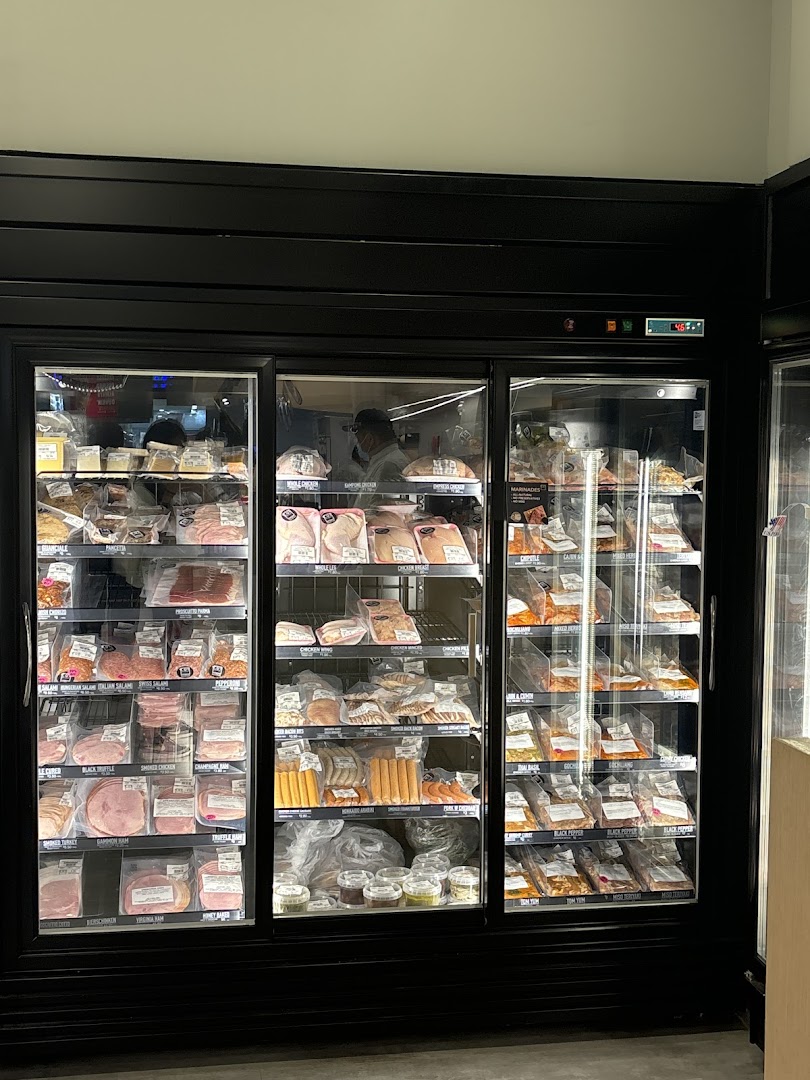 Refrigerated display cases filled with various packaged meat products inside a butchery.