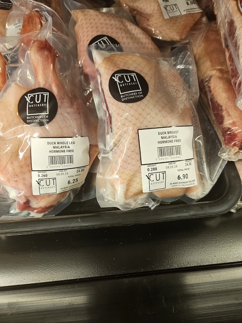 Packaged duck meat products with labels and prices in a display.