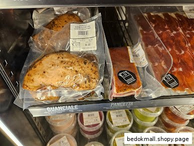 Packaged meat products and other items displayed in a refrigerated case.