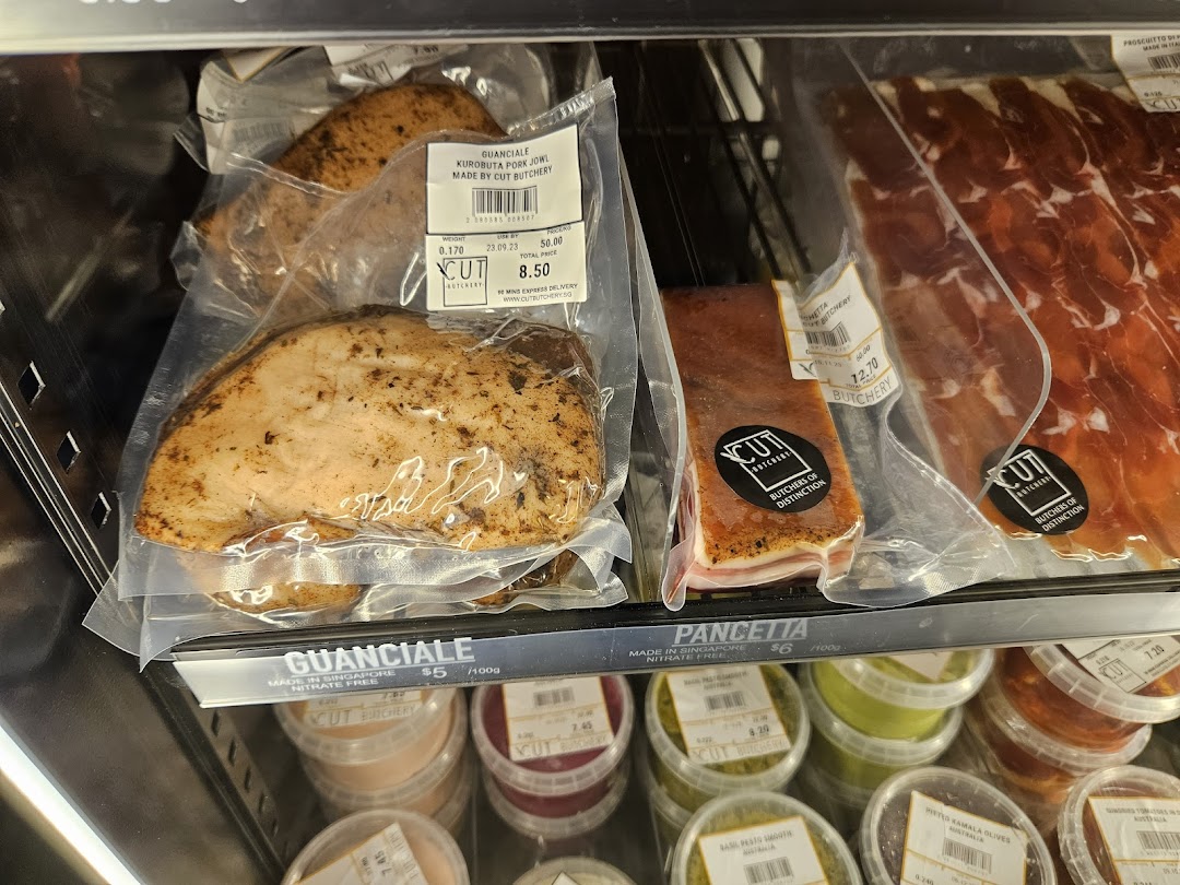 Packaged meat products and sauces displayed in a refrigerated case.