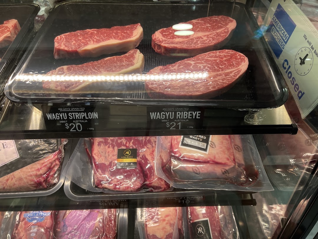 Refrigerated display case showing various cuts of Wagyu beef with prices.