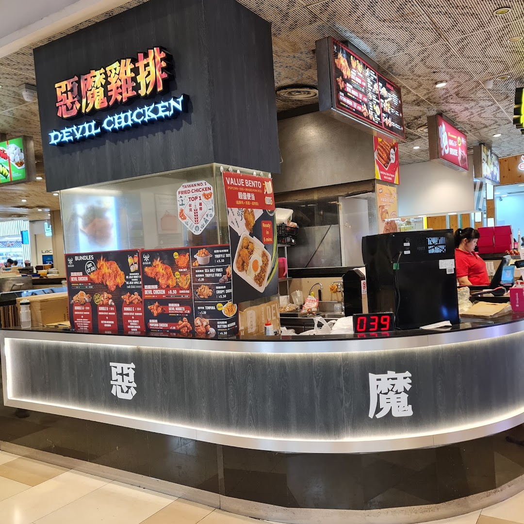 Interior view of a food stall counter with menu boards and staff.