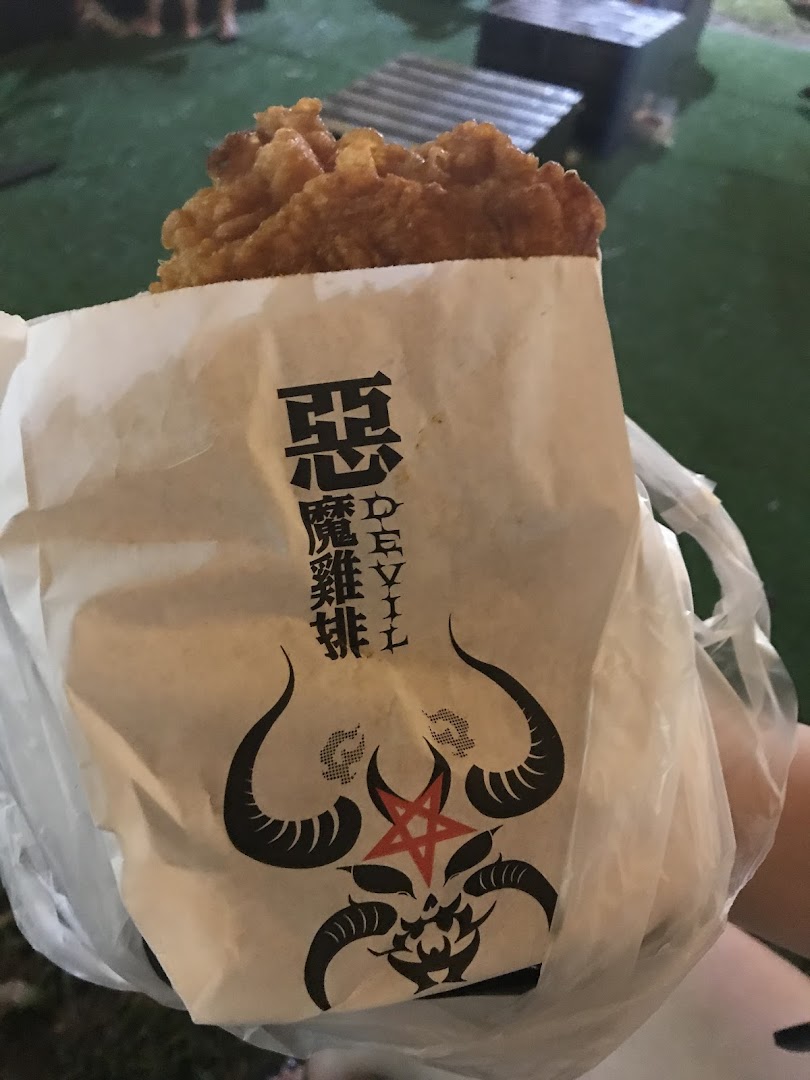 Fried chicken in a branded paper bag with a devil logo.