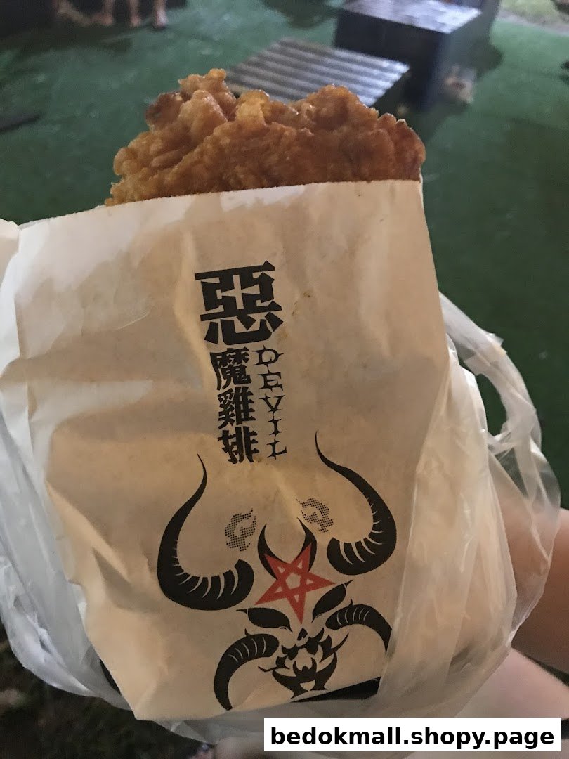 Fried chicken in a branded paper bag with a devil logo.