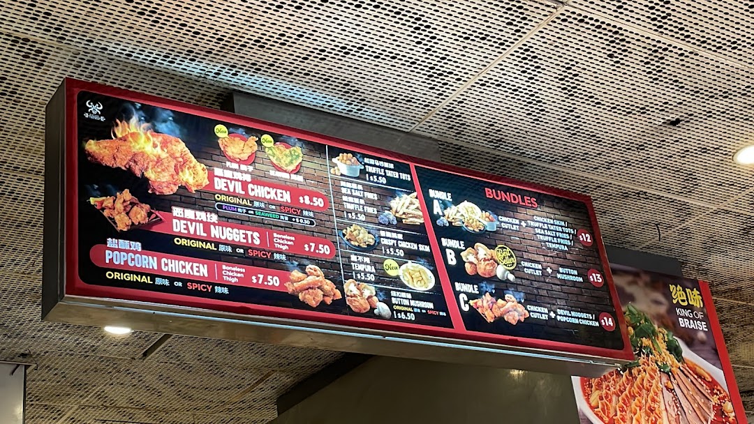 A brightly lit menu board displaying various fried chicken items, sides, and meal bundles.