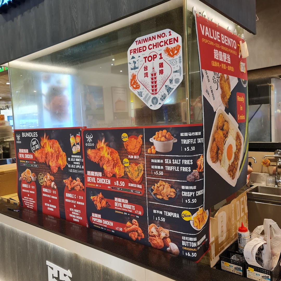 Counter with large menu boards displaying fried chicken dishes and prices.