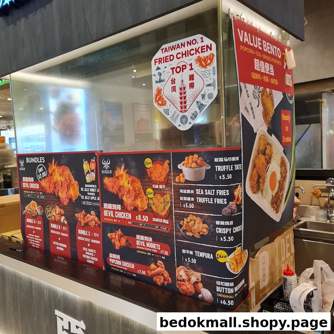 Counter with large menu boards displaying fried chicken dishes and prices.