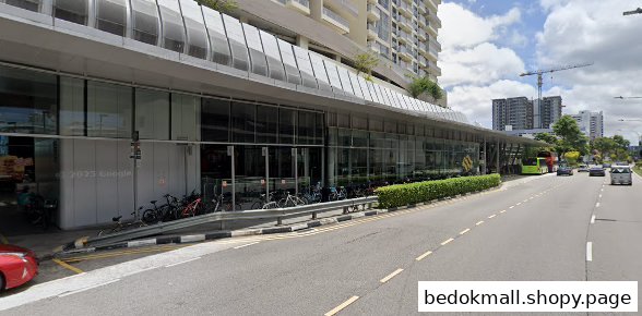 Exterior view of a modern building with glass windows, road, and parked bicycles.