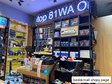 Interior view of a retail shop displaying electronics and accessories on shelves and a counter.
