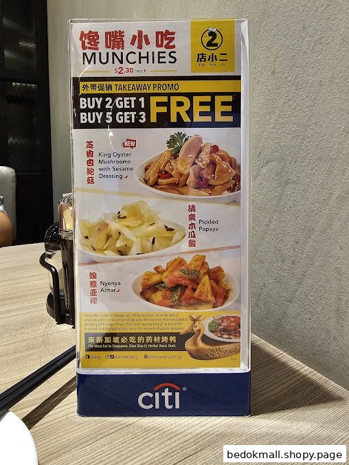 A table display showing food items, prices, and takeaway promotions.