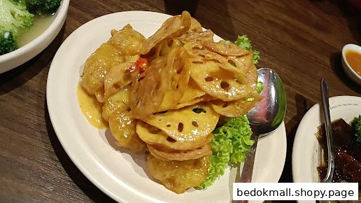 A dish of fried lotus root and chicken/fish with sauce and lettuce.