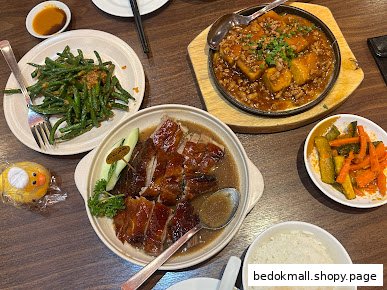 Table laden with various Chinese dishes, including roast duck and green beans.