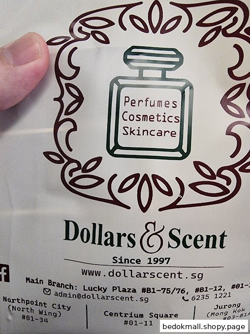 Close-up of a Dollars & Scent bag/flyer with logo and contact information.