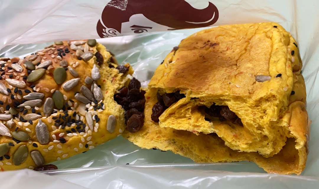 Two pieces of bread, one with seeds and one with raisins, in a plastic bag.
