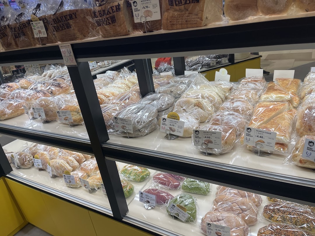 Shelves filled with various packaged bread and pastries inside a bakery.