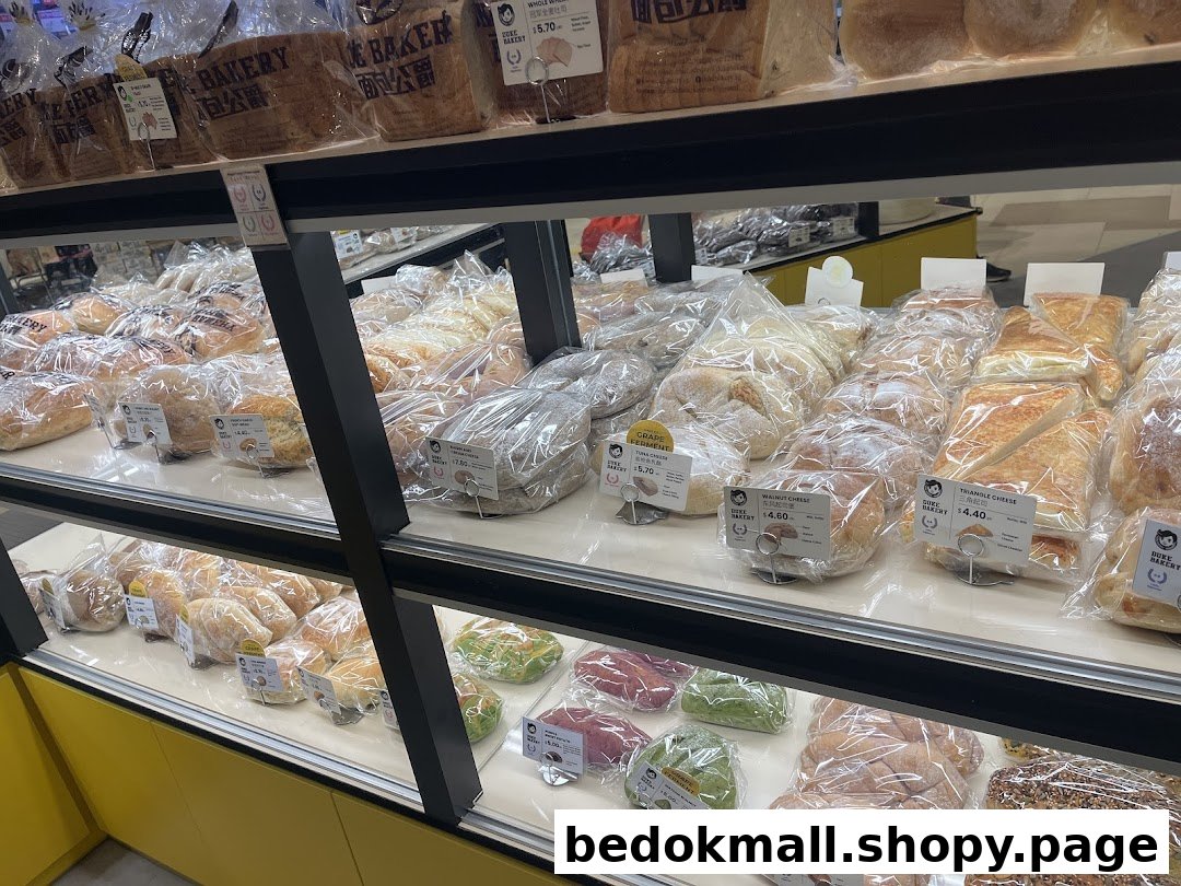Shelves filled with various packaged bread and pastries inside a bakery.