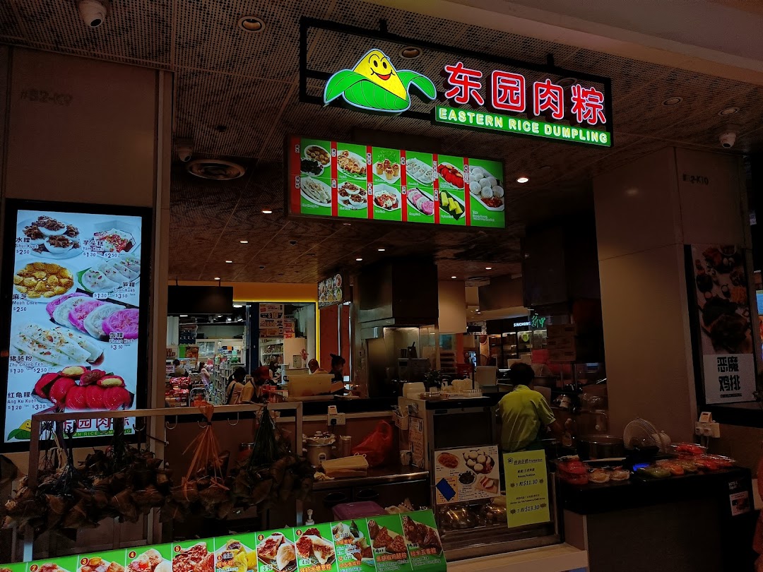 Interior view of a food stall counter with products, staff, and menus.