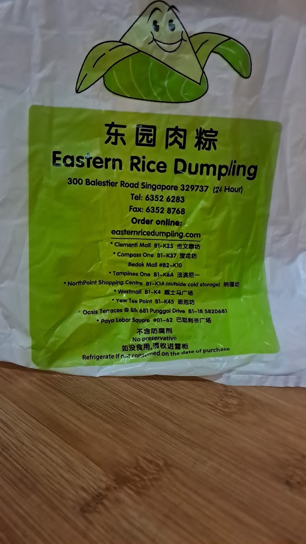 White bag with green label displaying business name, contact details, and branch locations.