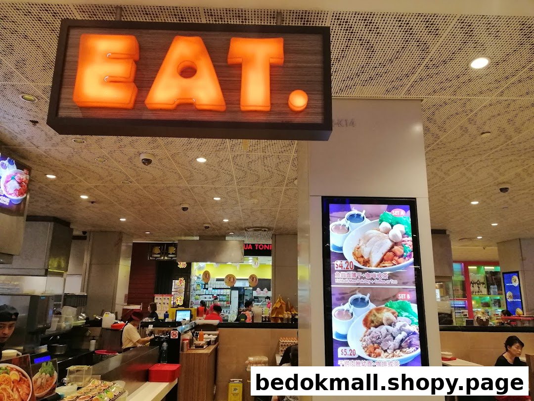 Interior view of EAT. food stall with counter, staff, and digital menu.