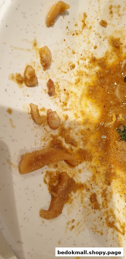 White plate with food remnants and sauce.
