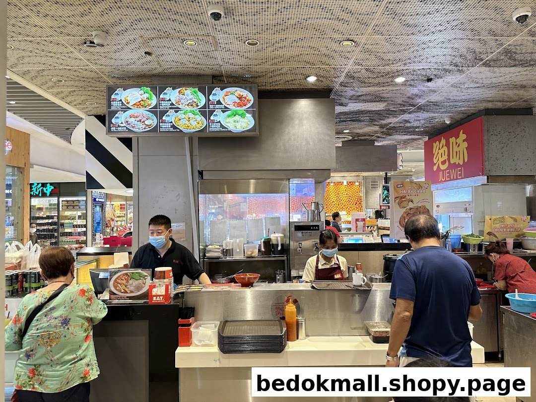 Busy food stall with staff serving customers and a menu display.