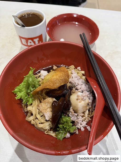 A bowl of noodles with toppings, a cup of coffee, and a small bowl of soup.