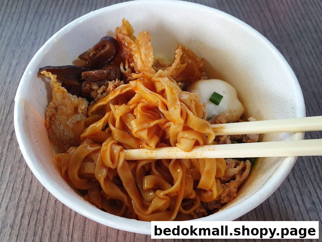 A close-up of a bowl of noodles with various toppings and chopsticks.