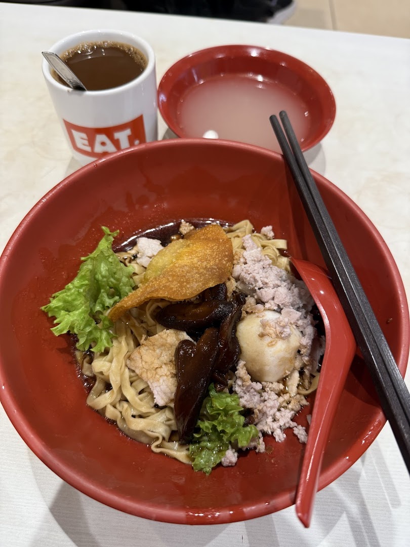 Close-up of a noodle dish with a drink and soup.