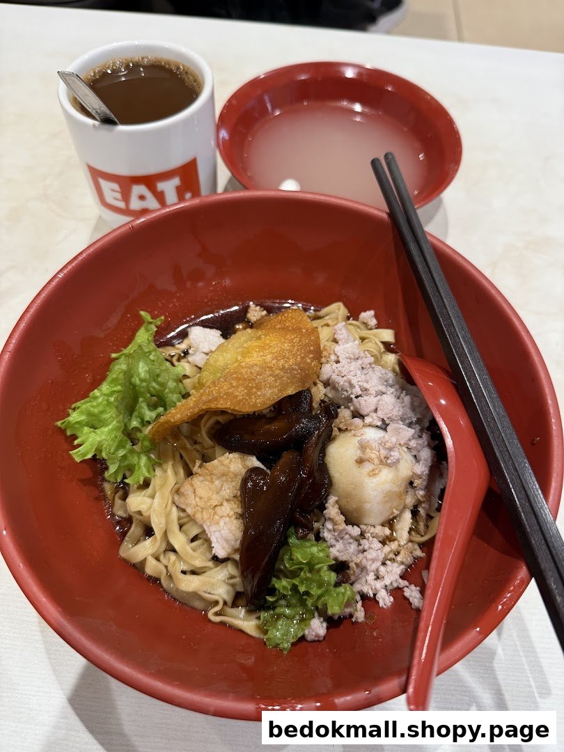 Close-up of a noodle dish with a drink and soup.