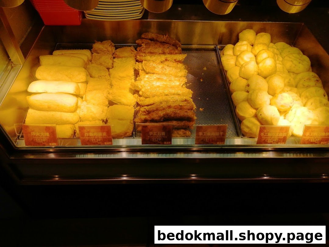 A display case filled with various fried food items and price tags.