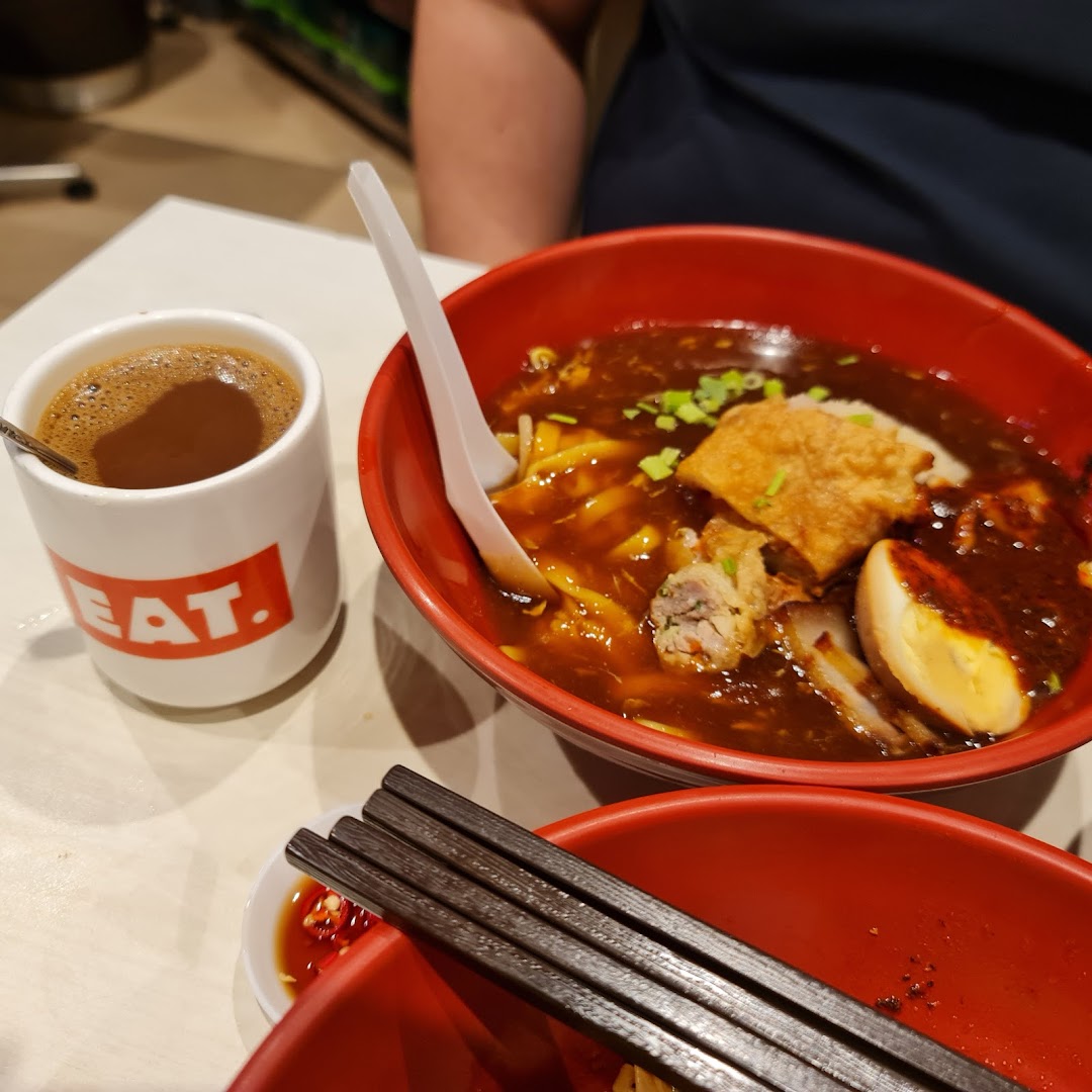 A bowl of noodles and a cup of coffee on a table.