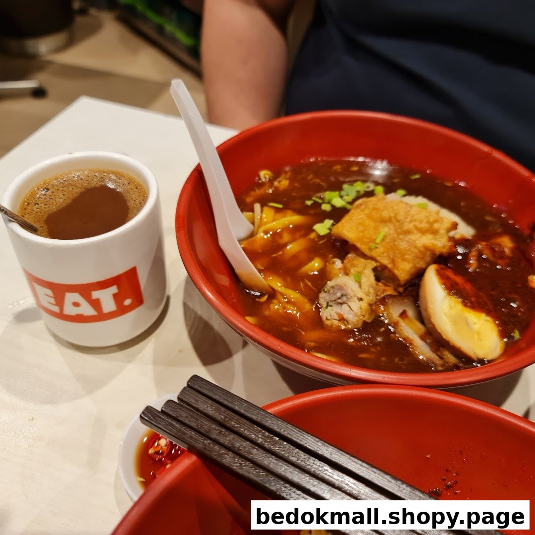 A bowl of noodles and a cup of coffee on a table.