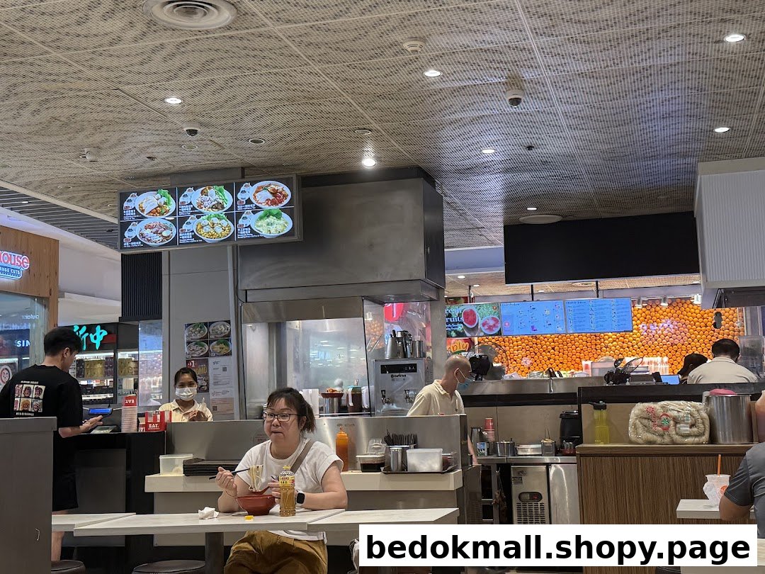 Interior view of a food court with customers eating and staff working.