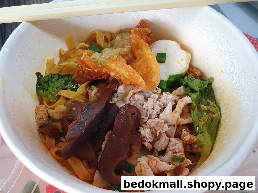 A close-up of a bowl of noodles with various toppings and chopsticks.