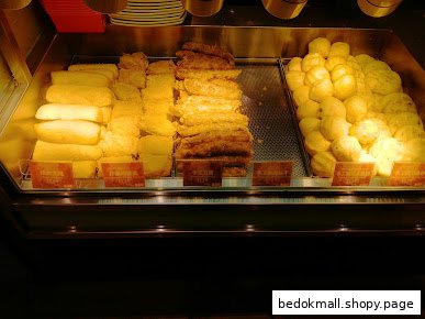 Heated display case filled with various fried food items.