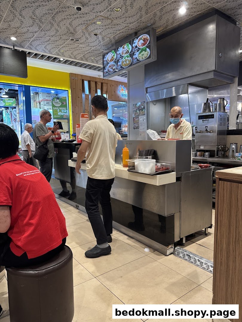 Interior view of a food stall with customers and staff.