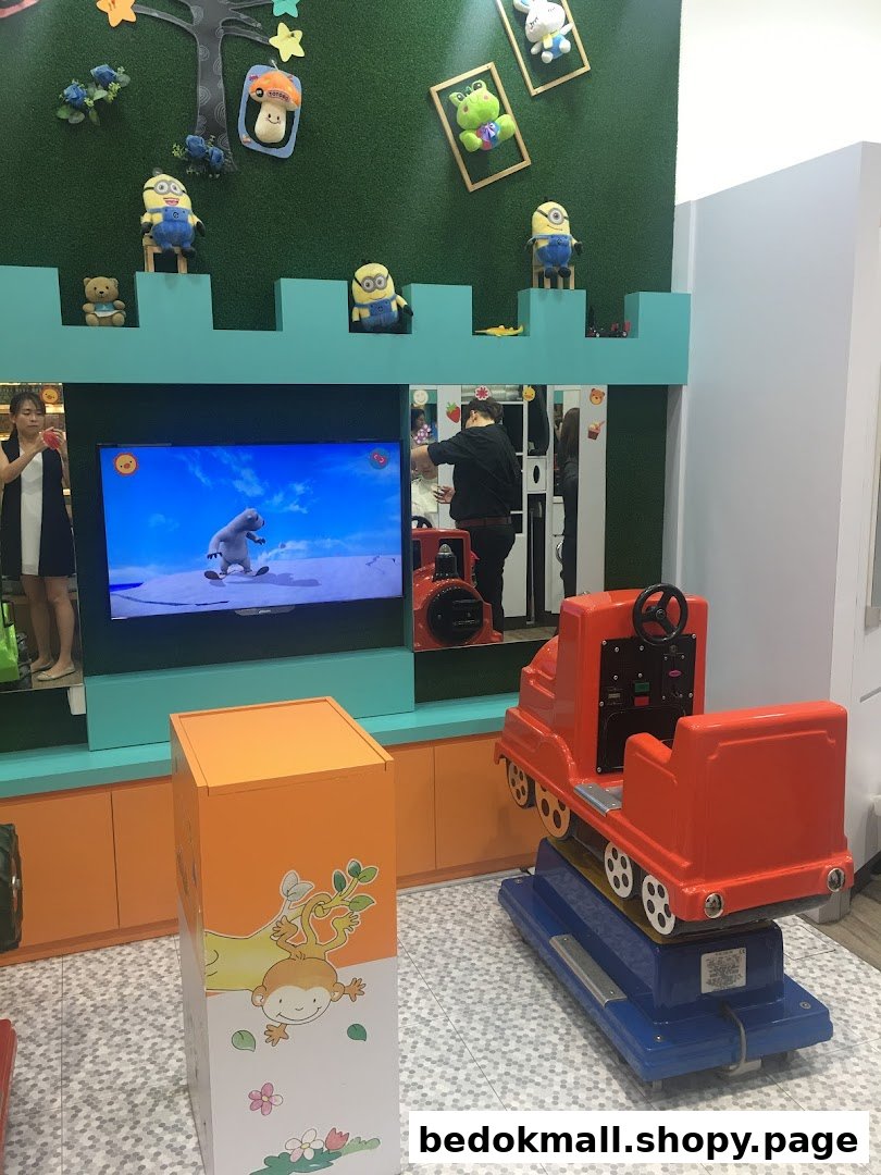 Interior of a shop with a TV, train ride, and Minion decorations.
