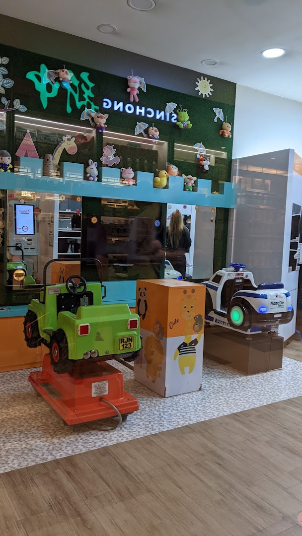 Interior view of a shop with two kiddie rides and a decorated wall.