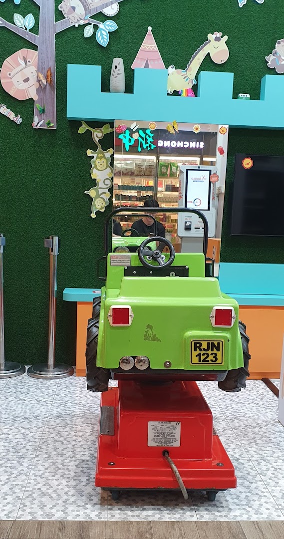 Green ride-on toy in a shop with cartoon animal decorations.
