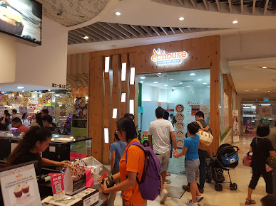 People entering and exiting the EC House shop front in a mall.