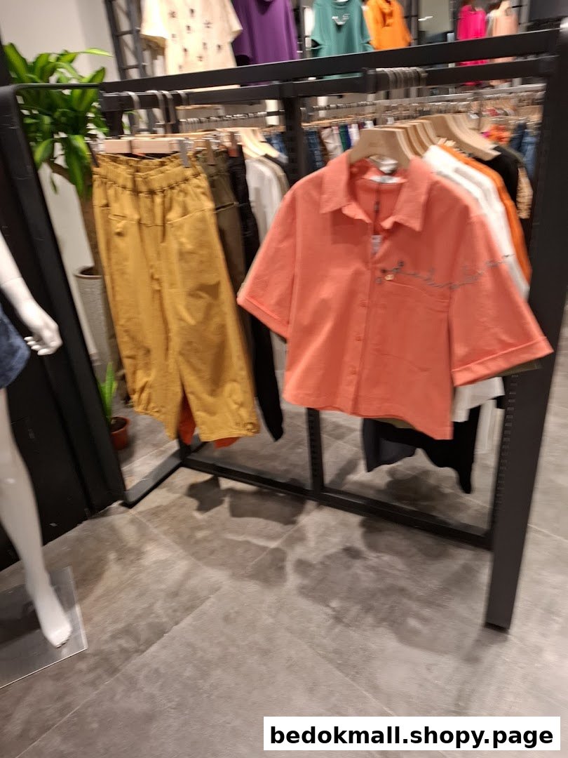 Clothing racks with various garments and a mannequin inside a shop.